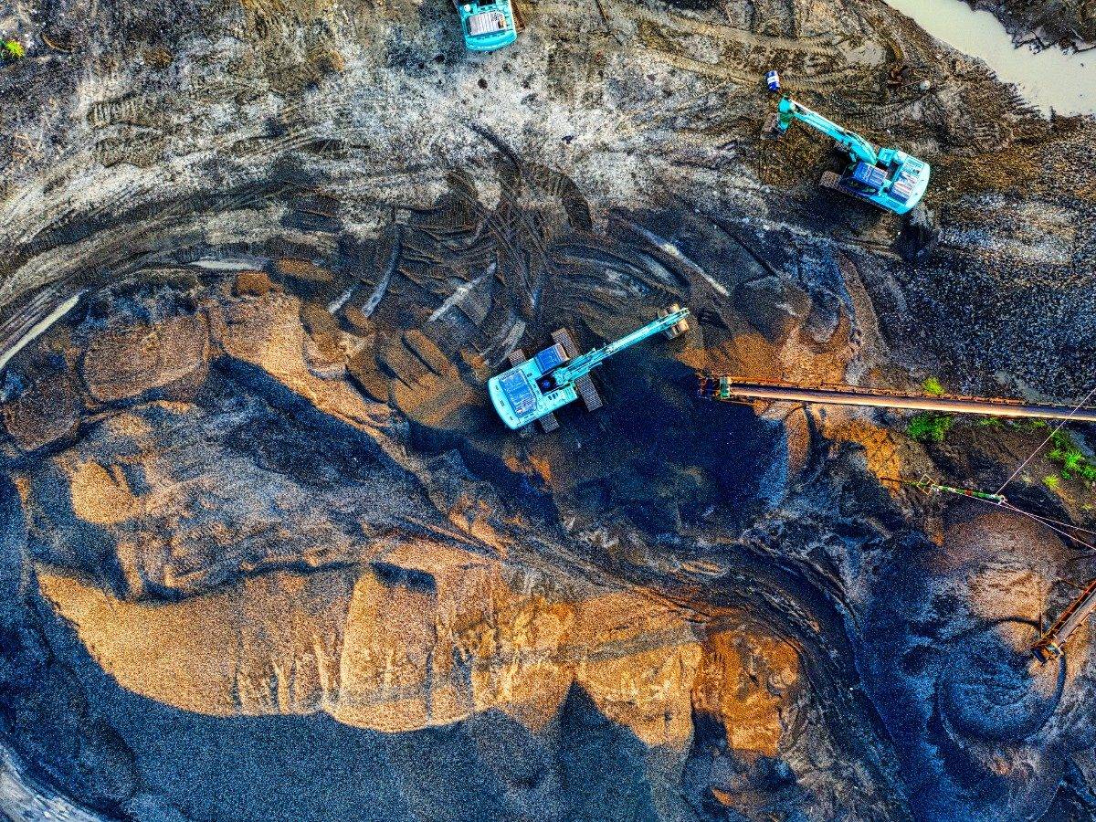 Excavator working an ore stockpile
